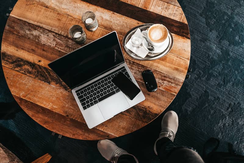 מחשב נייד וכוס קפה על שולחן משרדי